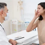 Doctor assessing vertigo symptoms in tourist at Bali clinic.